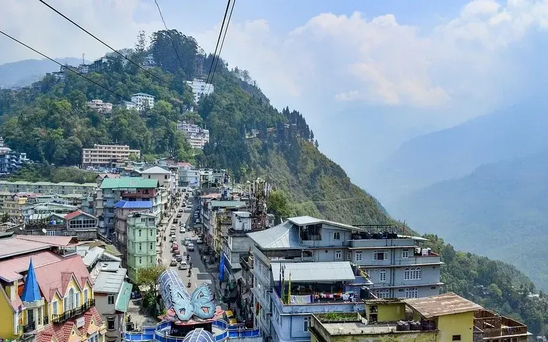 Beautiful landscape of Sikkim featuring Himalayan mountains, green valleys, and clear sky.